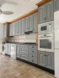 a kitchen with white cabinets and white appliances at Beni Qásim 1915 in Benicàssim