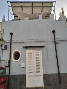 - un bâtiment blanc avec une porte et une fenêtre dans l'établissement Dammuso SoleLuna., à Terrasini
