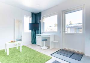 een witte kamer met een bureau en een raam bij Yksiö Turun Hirvensalossa in Turku +9 foto's