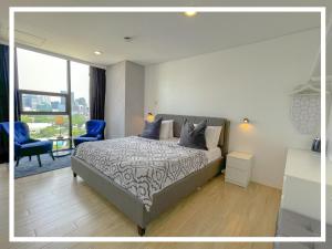 1 dormitorio con 1 cama y 1 silla azul en Premier Suite- Panoramic View, en Cebú