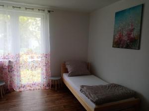 a small bedroom with a bed and a window at Apartmány Jablunkov in Jablunkov