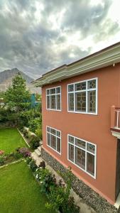 a pink house with a yard at Taaj Residence Skardu in Skardu