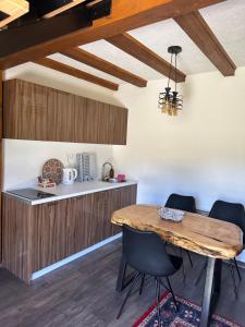 eine Küche mit einem Holztisch und Stühlen in der Unterkunft Apartmani nisicka oaza 2 in Ilijaš