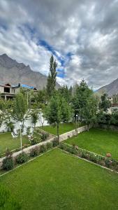 a view of a garden with mountains in the background at Taaj Residence Skardu in Skardu
