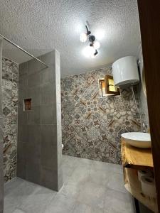 uma casa de banho com um lavatório e um chuveiro em Apartmani nisicka oaza 2 em Ilijaš
