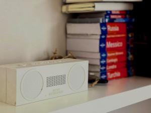 a white microwave sitting on a shelf with books at Mamma Ciccia Holiday Home - Cozy Attic in Galbiate