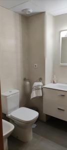 biała łazienka z toaletą i umywalką w obiekcie APART-DUPLEX-ATICO Tomares w mieście Tomares