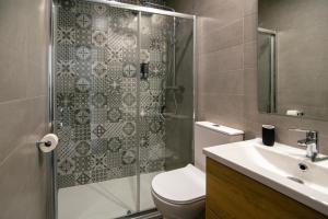 a bathroom with a shower and a toilet and a sink at Granadi Apartamentos in Granada