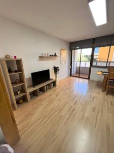 a living room with wooden floors and a flat screen tv at Ca La Noa 2 in Viladecáns