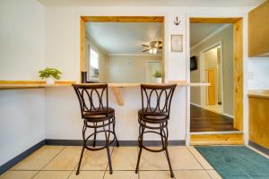 eine Küche mit zwei Barhockern und einer Theke in der Unterkunft Geneva Cottage with Patio - Walk to Park, Lake Erie! in Geneva-on-the-Lake + 23 Fotos