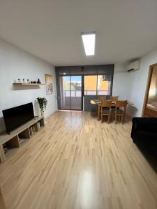 ein Wohnzimmer mit Holzboden und einem Tisch in der Unterkunft Ca La Noa 2 in Viladecáns