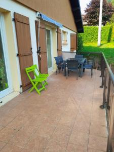 een patio met groene stoelen en een tafel en stoelen bij Maison de 3 chambres avec jardin clos et wifi a Morbier in Morbier