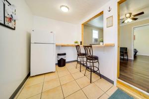 eine Küche mit einem weißen Kühlschrank und zwei Barhockern in der Unterkunft Geneva Cottage with Patio - Walk to Park, Lake Erie! in Geneva-on-the-Lake