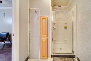 La salle de bains est pourvue d'une douche et d'une porte en verre. dans l'établissement Geneva Cottage with Patio - Walk to Park, Lake Erie!, à Geneva-on-the-Lake