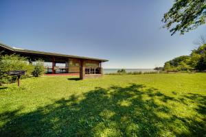 una casa en medio de un campo verde en Geneva Cottage with Patio - Walk to Park, Lake Erie!, en Geneva-on-the-Lake
