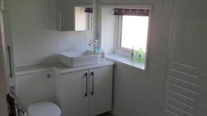 a bathroom with a sink and a toilet and a window at junction house in Stockton-on-Tees