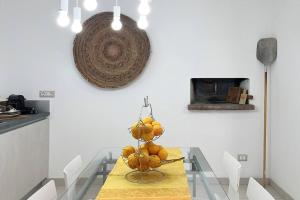 een eetkamer met een tafel met pompoenen erop bij casARCHÉ in Porto Torres