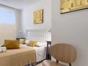 een hotelkamer met 2 bedden en een stoel bij casARCHÉ in Porto Torres