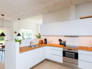 eine Küche mit weißen Schränken und einem Waschbecken in der Unterkunft Captivating Holiday home in L kken with Whirlpool in Løkken