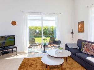 ein Wohnzimmer mit einem Sofa und einem Tisch in der Unterkunft Captivating Holiday home in L kken with Whirlpool in Løkken