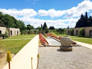 a garden with a row of flowers and a pathway at Les Madones in Nîmes