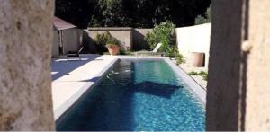 una piscina con agua azul en un patio trasero en Les Madones, en Nimes