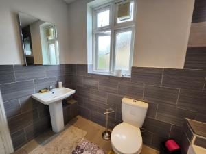 a bathroom with a toilet and a sink at Spacious Room with Garden in Croydon London in South Norwood