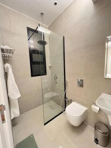 a bathroom with a toilet and a glass shower at New apartment, two entrances in Riyadh