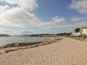 a sandy beach with buildings and the ocean at Silverbells in Millport
