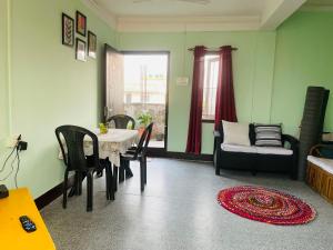 d'une salle à manger avec une table, des chaises et une fenêtre. dans l'établissement Nyla homestay Naharlagun, à Bacha