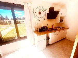a kitchen with a counter and a large window at Les Madones in Nîmes