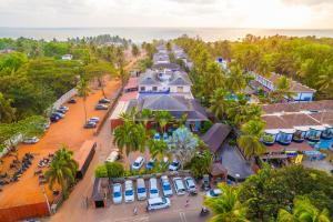 - une vue aérienne sur un complexe avec des voitures garées sur un parking dans l'établissement O Hotel Goa, Candolim Beach, à Candolim