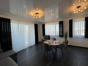 a living room with a table and chairs and windows at Apartaments PopDan Residence by the Sea in Eforie Nord +29 photos
