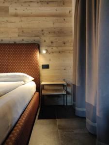 sypialnia z łóżkiem i stolikiem w obiekcie BAITA LARIX BORMIO w mieście Bormio