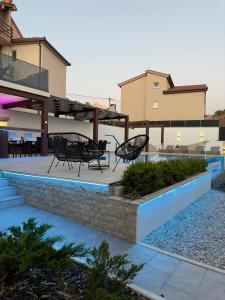 a patio with two black chairs and a table at Holiday Home Korda in Čapljina