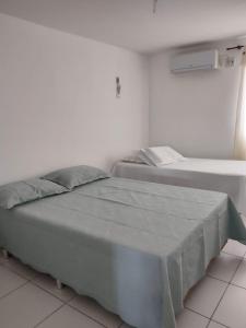 1 Schlafzimmer mit 2 Betten in einem weißen Zimmer in der Unterkunft Flat c/ 2 qts em Gravatá in Gravatá