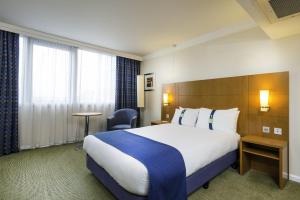 a hotel room with two beds and a desk at Holiday Inn - Glasgow Airport, an IHG Hotel in Paisley
