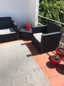 a patio with two chairs and a rug at Casa do Mercador by Portus Alacer in Avis
