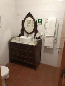 y baño con lavabo, espejo y aseo. en Casa do Mercador by Portus Alacer, en Avis