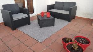 a patio with two chairs and a table with red candles at Casa do Mercador by Portus Alacer in Avis