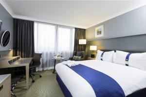 a hotel room with a large bed and a desk at Holiday Inn - Glasgow Airport, an IHG Hotel in Paisley