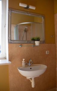 a sink in a bathroom with a mirror and a window at Open Doors Villa in Gdańsk