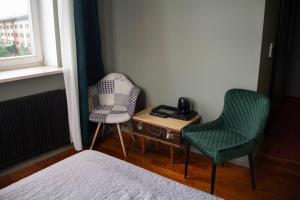 sypialnia z 2 krzesłami, stołem i łóżkiem w obiekcie Open Doors Villa w Gdańsku