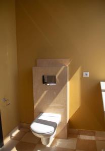 a bathroom with a white toilet in a yellow wall at Open Doors Villa in Gdańsk