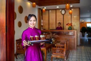 Una mujer sosteniendo una bandeja con velas. en ZEN RETREAT HOI AN en Hoi An