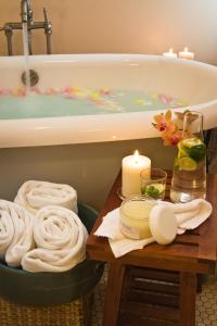 阿什蘭的住宿－阿什蘭溫泉酒店，带浴缸的浴室以及带毛巾的桌子。