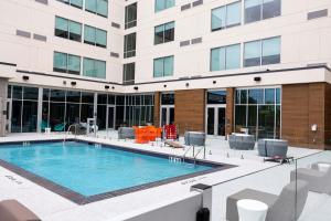 a swimming pool in front of a building at Aloft Dallas DFW Airport Grapevine in Coppell