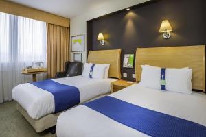 a hotel room with two beds and two lamps at Holiday Inn - Glasgow Airport, an IHG Hotel in Paisley