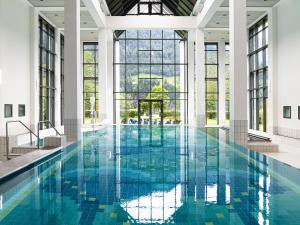 a pool with blue tiles in a building with windows at Quadern Apartmenthaus B204 in Bad Ragaz
