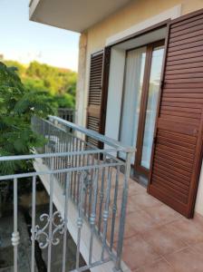 - un balcon d'une maison avec une porte en bois dans l'établissement B&B Mazzini, à Grottaglie